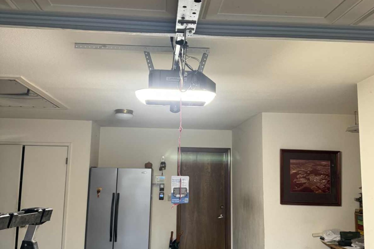 New garage door opener installation image showing a technician installing a modern automatic opener on a door system. This service includes advanced safety features, quiet operation, and smooth functionality. Professional installation ensures long-lasting reliability, enhanced security, and convenient daily use for residential and commercial doors.